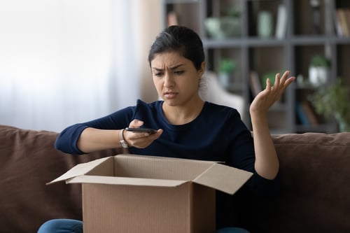 Frau mit geöffneten Paket und Handy