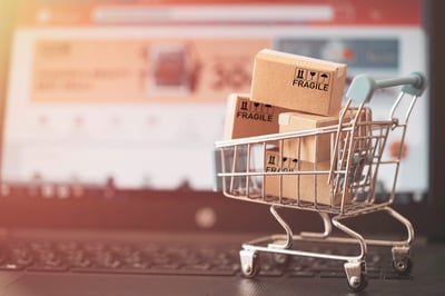 kleiner Einkaufswagen auf Laptop