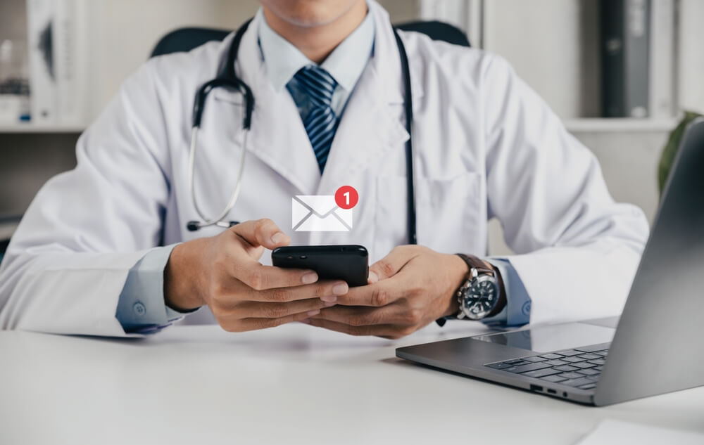 Arzt mit Handy Nachricht